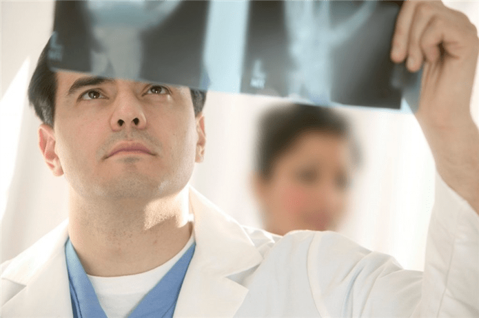 lekár skúma obraz bedrového kĺbu s artrózou